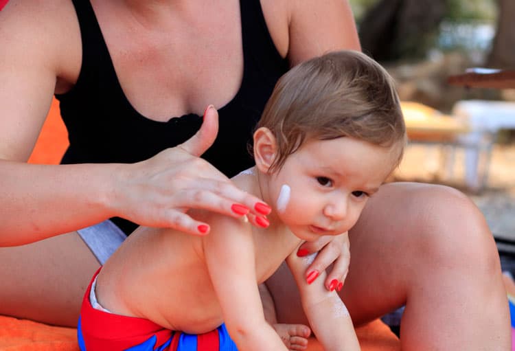 Mom Putting Sunscreen On Baby