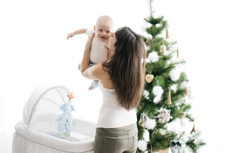 Mom Getting Ready To Put Baby To Sleep At Christmas