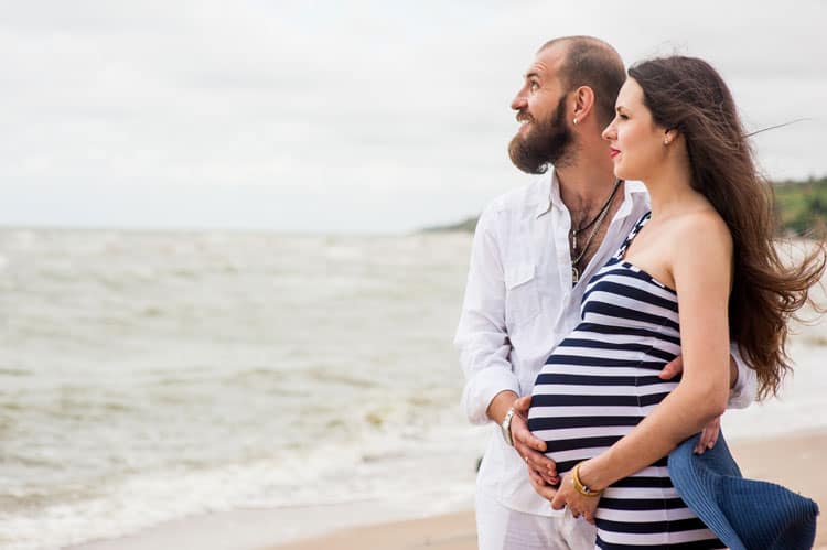 Expecting Mom With Her Husband On The Beach