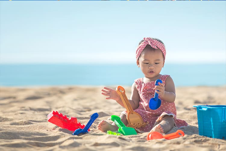 Asian Girl Playing In The Sand At St. Pete Beach