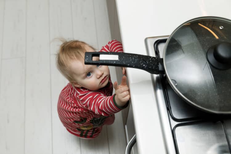 Baby Reaching For A Hot Pan On The Stovetop