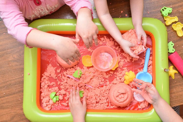 Children Playing In A Sensory Bin