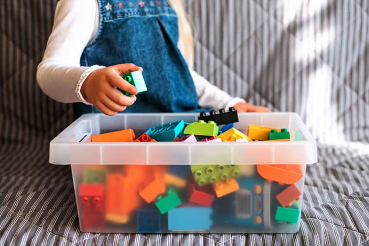 Girl Playing With Bin Of Building Blocks