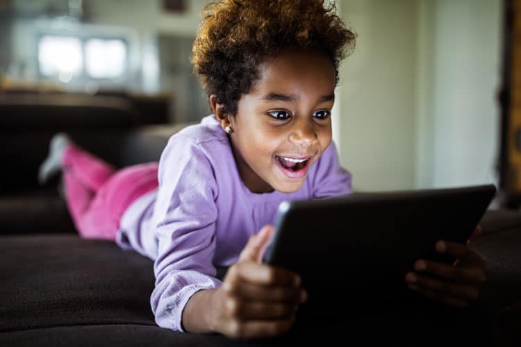 Child Playing On Ipad While Parents Are Working From Home