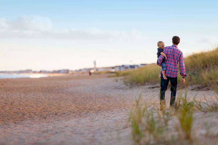 Father And Child Walking On Beach