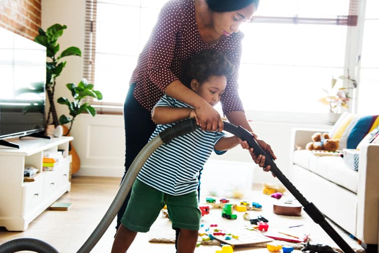 Mother Helpinng Her Child Vacuum