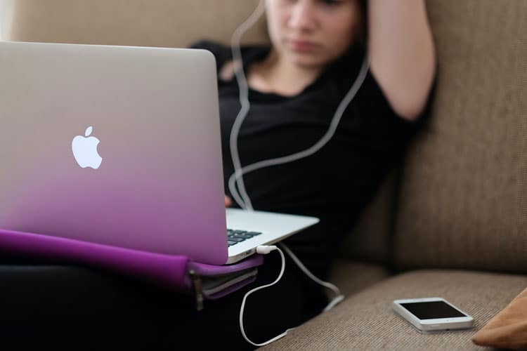 Girl On Couch With Computer And Phone